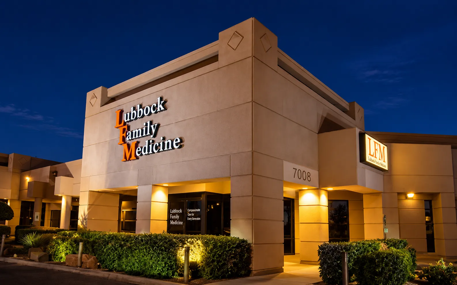 Lubbock Family Medicine clinic building at dusk, with the practice name lit above the entrance