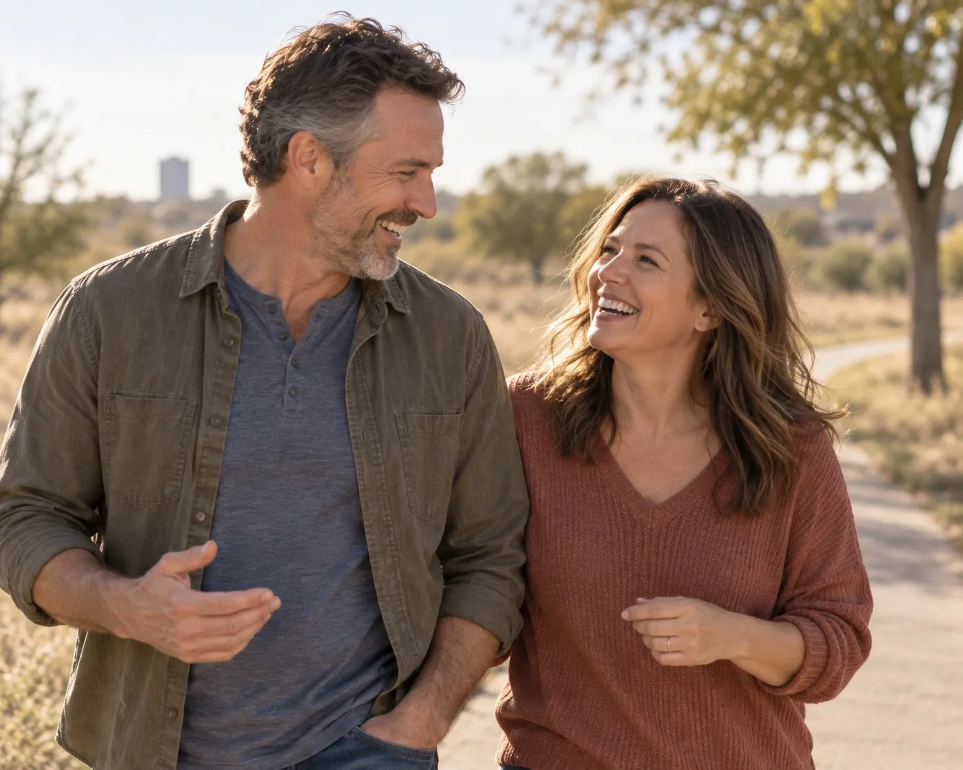 A couple laughing together outdoors on a sunny day